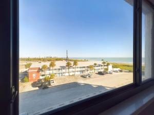 a window with a view of a beach and the ocean at Sandcastles 2br2ba Cocoa Beach Ocean Views! in Cocoa Beach