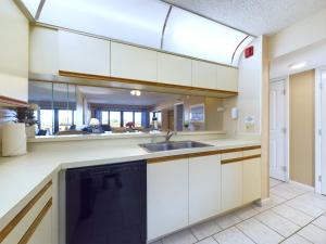 a kitchen with white cabinets and a sink at Sandcastles 2br2ba Cocoa Beach Ocean Views! in Cocoa Beach