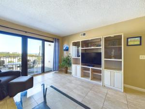 a living room with a couch and a tv at Sandcastles 2br2ba Cocoa Beach Ocean Views! in Cocoa Beach