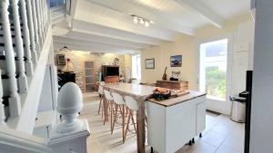 a kitchen with a island with bar stools at Audierne, Finistère, Maison Vue Mer in Plouhinec +21 photos