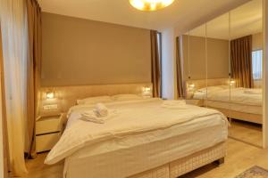 a bedroom with a large bed and a large mirror at Uni88 ApartHotel in Bucharest