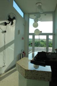 a kitchen with a counter and a large window at Hotel Flamboyant in Itaquaquecetuba