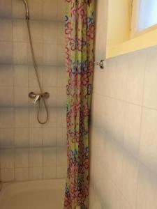 a shower with a colorful shower curtain in a bathroom at Tulman Apartment in Balatonberény