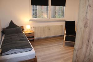 Un dormitorio con una cama, un escritorio y una silla. en FeWo Oberhausen-Styrum, en Oberhausen
