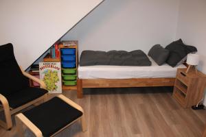 1 dormitorio con cama, silla y estante para libros en FeWo Oberhausen-Styrum, en Oberhausen 3 fotos más