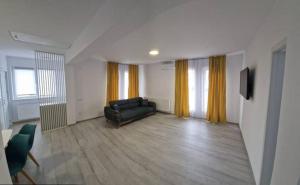 a living room with a couch and a television at myHome Residence in Nazna