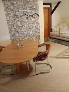 a table and chairs in a room with a stone wall at Haus Hopfgarten in Schwalmtal