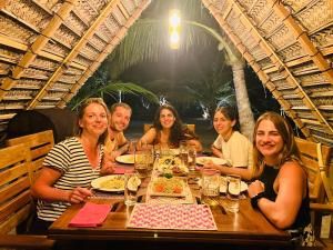 蒂瑟默哈拉默YALA Turtle Bay Hostel的一群人坐在桌旁吃饭