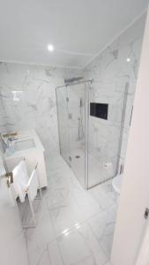 ein weißes Badezimmer mit Dusche und Waschbecken in der Unterkunft Casa Terra Mar in Angra do Heroísmo + 42 Fotos