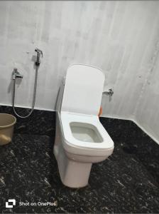 a white toilet in a bathroom with a shower at Swastik Holiday Home in Arambol +5 photos