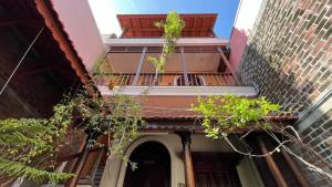 a building with a balcony with plants on it at Charme de Pondicherry by stayxp in Puducherry