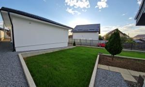 a yard with a white wall and a green lawn at myHome Residence in Nazna