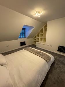 a bedroom with a large white bed and a window at Lux House, Jennett's Park in Bracknell