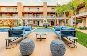 a patio with chairs and a table and a pool at Casa Itacimitim Praia do Surf in Camacari