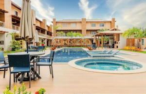 a patio with a table and chairs and a swimming pool at Casa Itacimitim Praia do Surf in Camacari