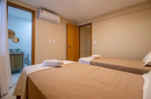 a hotel room with two beds and a window at Casa Itacimitim Praia do Surf in Camacari +19 photos