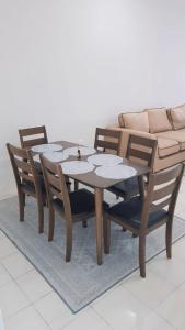 a wooden table and chairs with a couch at AMAN Homestay Senawang musliim only in Senawang