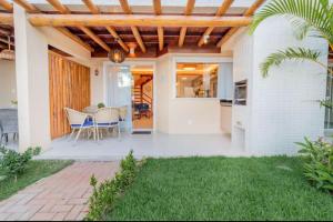 a home with a patio with a table and chairs at Casa Itacimitim Praia do Surf in Camacari