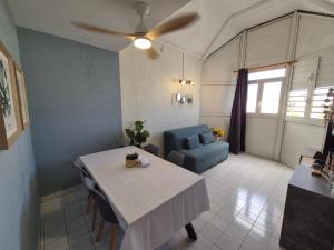 a living room with a table and a blue couch at Coeur Citadin - 4 personnes - Plein Centre Ville 2eme étage in Saint-Denis