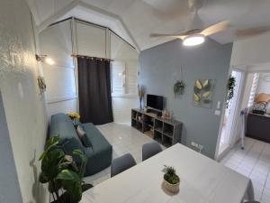 a living room with a couch and a table at Coeur Citadin - 4 personnes - Plein Centre Ville 2eme étage in Saint-Denis