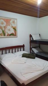 a bedroom with a bed with a picture on the wall at Pousada Toka do Lula - Oficial in Peruíbe