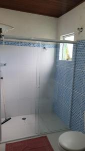 a bathroom with a glass shower with a toilet at Pousada Toka do Lula - Oficial in Peruíbe