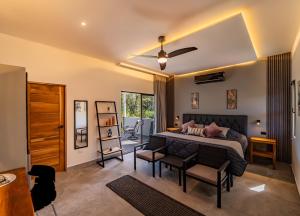 a bedroom with a bed and a table and chairs at Hotel Casa Buenavista - Adults only in Sámara
