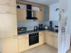 a kitchen with wooden cabinets and a stove top oven at La Pura Vida in Bühlertann