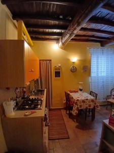 - une cuisine et une salle à manger avec une table et une cuisinière dans l'établissement GRAZIOSO Appartamento, à Spolète
