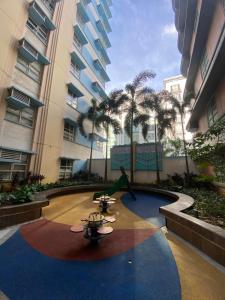 un patio con palmeras en un edificio grande en 101newport Condotel Near NAIA T3, en Manila