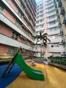 un parque infantil frente a un edificio alto en 101newport Condotel Near NAIA T3, en Manila