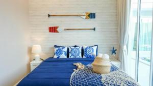 een slaapkamer met een blauw bed met blauwe kussens bij Fin Camping & Pool Villa in Ban Hup Kaphong