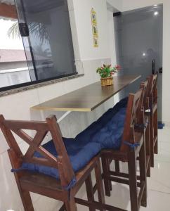 un bar con sedie e cuscini blu a un tavolo di Bangalô MAR & SOL a Saquarema