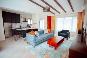 a living room with a couch and a kitchen at Phelgone Nanyuki in Nanyuki