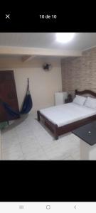 a bedroom with a bed and a hammock in it at Suítes in Fonseca