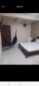 a room with a bed and a hammock in it at Suítes in Fonseca
