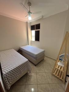 Apartamento na Quadra da Praia! في فيلا فيلها: غرفة نوم بها سرير ومروحة سقف