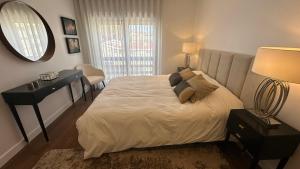 a bedroom with a bed and a desk and a mirror at River View apartment in Chaves
