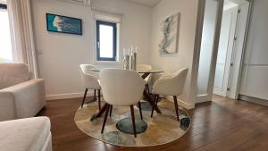 a dining room with a table and white chairs at River View apartment in Chaves +3 photos