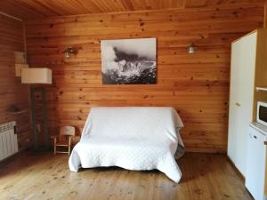 a bedroom with a bed in a wooden wall at La Cabane d'Oza in Saint-Pierre-dels-Forcats