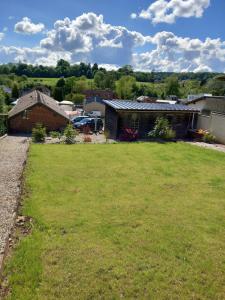 a yard with a house and a field of grass at Chez Sabine et Sarah in Gacé