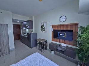 a living room with a tv and a kitchen at Cozy Condo in the City Center at Horizons 101 in Cebu City +29 photos
