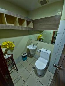 a bathroom with a toilet and a sink at Cozy Condo in the City Center at Horizons 101 in Cebu City