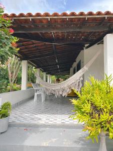 a hammock on the porch of a house at Sítio Caju in Aquiraz +4 photos