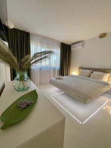 a bedroom with a bed and a vase on a table at Luxury apartament40 in Craiova