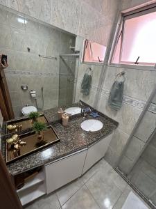 Apartamento na Quadra da Praia! في فيلا فيلها: حمام مع مغسلتين ودش