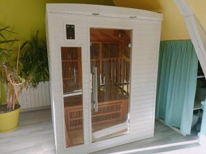 a small white building with a cage in a room at Sauna dans Maison de maître proche Etretat -étage2 in Rolleville