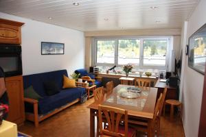 a living room with a blue couch and a table at ALPINSTAR in Chamonix-Mont-Blanc