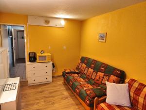 a living room with a couch and a microwave at Résidence Au Petit Chamois in Le Corbier