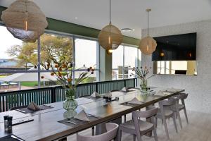 a dining room with a long table and chairs at Town Lodge Bellville in Bellville